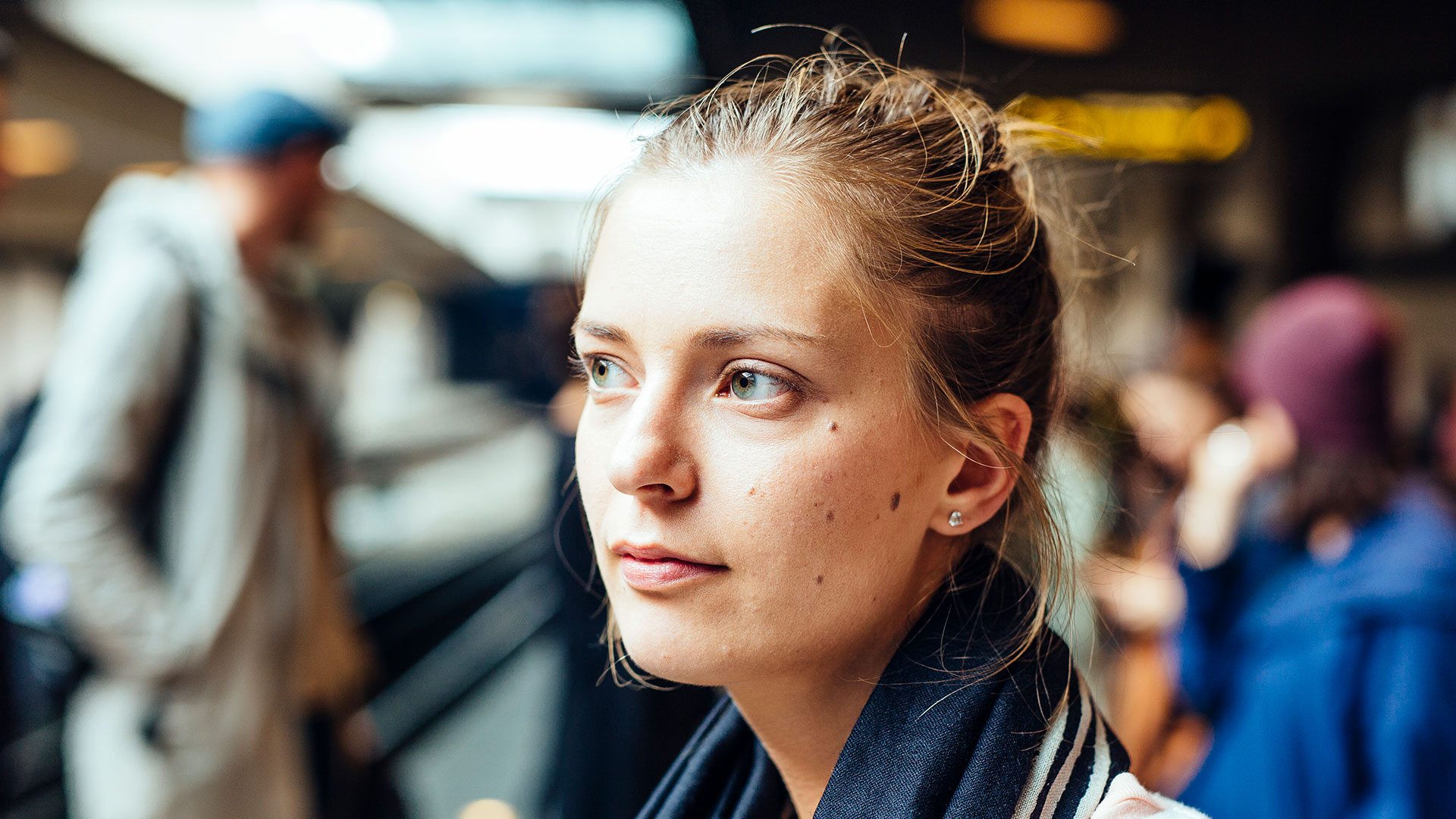 Young Woman Lost In Thought At A Bustling Train Station